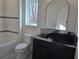 Bathroom with granite countertop, black vanity, and arched mirror at 135 Cedarwood Ln, Roswell, GA 30075