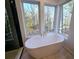 Relaxing bathroom with free-standing tub and forest views at 135 Cedarwood Ln, Roswell, GA 30075