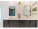 Bathroom featuring double sinks, black cabinets, white countertop, and decorative lighting at 135 Cedarwood Ln, Roswell, GA 30075