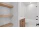 Modern bathroom featuring a soaking tub, floating shelves, and contemporary fixtures at 135 Cedarwood Ln, Roswell, GA 30075