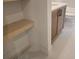 Close up of a wooden vanity with a white countertop next to a shelf at 135 Cedarwood Ln, Roswell, GA 30075