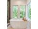 Bright bathroom with a freestanding tub, tray, and natural light from the windows at 135 Cedarwood Ln, Roswell, GA 30075