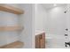 Modern bathroom with tub, shower, wooden vanity, and open shelving at 135 Cedarwood Ln, Roswell, GA 30075