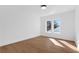 Bedroom with hardwood floors, white walls, and two windows offering natural light and wooded views at 135 Cedarwood Ln, Roswell, GA 30075