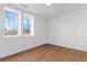 Bright bedroom featuring hardwood floors, two windows for natural light, and neutral walls at 135 Cedarwood Ln, Roswell, GA 30075