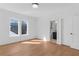 Bright bedroom featuring hardwood floors, two windows for natural light, and access to a bathroom at 135 Cedarwood Ln, Roswell, GA 30075