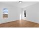 Bedroom with hardwood floors and trim, white walls and two windows with natural light at 135 Cedarwood Ln, Roswell, GA 30075