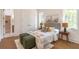 Cozy bedroom features stylish furnishings, including a bed with decorative pillows, two ottomans, and two bedside lamps at 135 Cedarwood Ln, Roswell, GA 30075