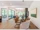 Bright dining room features modern chandelier, glass table and access to an outdoor living area at 135 Cedarwood Ln, Roswell, GA 30075