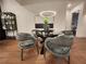 Dining room featuring a modern chandelier, a round glass table, and comfortable seating for elegant dining experiences at 135 Cedarwood Ln, Roswell, GA 30075