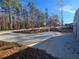 View of a concrete driveway and garage, and landscape wall with trees in the background at 135 Cedarwood Ln, Roswell, GA 30075