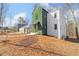 Modern two-story home with unique green and white exterior with driveway and landscaping at 135 Cedarwood Ln, Roswell, GA 30075