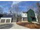 Contemporary home featuring a stylish green exterior with a connecting garage and modern design at 135 Cedarwood Ln, Roswell, GA 30075