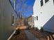 View of the side exterior featuring a covered entry, landscaped yard, and dark grey siding at 135 Cedarwood Ln, Roswell, GA 30075