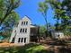 Striking two-story home with modern architecture, set among mature trees, includes an outdoor porch for elevated scenic views at 135 Cedarwood Ln, Roswell, GA 30075