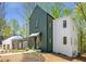 Modern farmhouse exterior with lush, mature trees and a landscaped yard at 135 Cedarwood Ln, Roswell, GA 30075