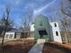 Contemporary home featuring a stylish green exterior with a connecting garage and modern design at 135 Cedarwood Ln, Roswell, GA 30075