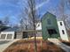 Contemporary home featuring a stylish green exterior with a connecting garage and modern design at 135 Cedarwood Ln, Roswell, GA 30075