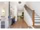 Bright foyer with hardwood floors, modern lighting, staircase, and an open view to the living spaces at 135 Cedarwood Ln, Roswell, GA 30075