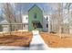 Modern home showcasing distinctive green siding, a walkway, and unique architectural details at 135 Cedarwood Ln, Roswell, GA 30075