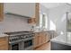 Bright kitchen features stainless appliances, light countertops and custom wood cabinetry at 135 Cedarwood Ln, Roswell, GA 30075