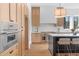 A modern kitchen featuring stainless steel appliances, a center island with seating, and custom wood cabinets at 135 Cedarwood Ln, Roswell, GA 30075