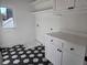 Bright laundry room with white cabinets and hexagon tile floor at 135 Cedarwood Ln, Roswell, GA 30075