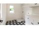 Laundry room showcasing patterned tile floor, white cabinets, and a window at 135 Cedarwood Ln, Roswell, GA 30075