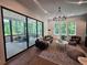 Bright living room with large windows, modern chandelier, and comfortable seating, connects to the outdoors with large sliding glass doors at 135 Cedarwood Ln, Roswell, GA 30075