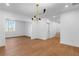 Open concept living room with hardwood floors, modern lighting, and bright, white walls at 135 Cedarwood Ln, Roswell, GA 30075