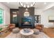 Cozy living room with a fireplace, modern light fixture, and warm, neutral tones at 135 Cedarwood Ln, Roswell, GA 30075