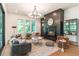 Sun-filled living room with modern lighting, a fireplace with dark wood paneling, and comfortable seating at 135 Cedarwood Ln, Roswell, GA 30075