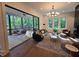 Open-concept living room boasts large windows, a stylish chandelier, and a seamless transition to the outdoor porch through sliding glass doors at 135 Cedarwood Ln, Roswell, GA 30075