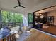Stylish covered porch with seating area flows seamlessly into the living room through a large sliding glass door, connecting indoor/outdoor spaces at 135 Cedarwood Ln, Roswell, GA 30075