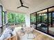 Relaxing covered porch featuring a ceiling fan, comfortable seating, and a sliding glass door leading to the indoors at 135 Cedarwood Ln, Roswell, GA 30075