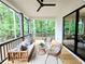 Inviting porch with comfortable seating and outdoor ceiling fan overlooks lush trees, offering a serene outdoor living space at 135 Cedarwood Ln, Roswell, GA 30075