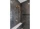 Close up of a glass shower with herringbone tile and gold hardware, including a rain shower head at 135 Cedarwood Ln, Roswell, GA 30075