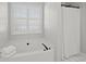 Bright bathroom featuring a soaking tub with shutters and a shower with elegant white tiling at 1515 Bullard Pl, Powder Springs, GA 30127