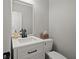 Charming half bathroom featuring a modern vanity, sleek fixtures, and a neutral color scheme at 1515 Bullard Pl, Powder Springs, GA 30127