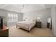 Bright bedroom with a tray ceiling, featuring a large window with shutters and neutral decor at 1515 Bullard Pl, Powder Springs, GA 30127