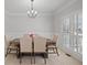 Formal dining room with wainscoting, a chandelier, and large window with bright lighting at 1515 Bullard Pl, Powder Springs, GA 30127