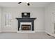 Cozy living room featuring a fireplace with white brick and dark mantel, and a large window at 1515 Bullard Pl, Powder Springs, GA 30127