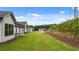 Backyard view of homes showcasing green lawn and wooded area at 320 Sobeck Way, Canton, GA 30115