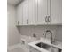 Laundry room with white cabinets and a utility sink at 320 Sobeck Way, Canton, GA 30115