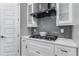 Modern kitchen with white cabinets, gas cooktop and gray tile backsplash at 1393 Lanier Pl, Atlanta, GA 30306