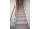 Beige carpeted staircase with wood railing at 2815 Shoemaker Ln, Snellville, GA 30039