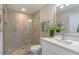 Modern bathroom with a walk-in shower, white vanity, and pebble floor at 3463 Victoria St, Atlanta, GA 30337