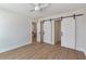 Bedroom with hardwood floors, white barn doors, and access to other rooms at 3463 Victoria St, Atlanta, GA 30337