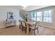 Bright dining room features a light wood table with six chairs, hardwood floors, and large windows at 3463 Victoria St, Atlanta, GA 30337