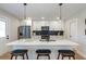 Modern kitchen with white cabinets, quartz countertops, stainless steel appliances, and island with seating at 3463 Victoria St, Atlanta, GA 30337